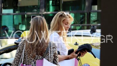 Η Μαριέττα Χρουσαλά στο κέντρο της Αθήνας κοιτώντας τα πράγματα που κρατάει στα χέρια της