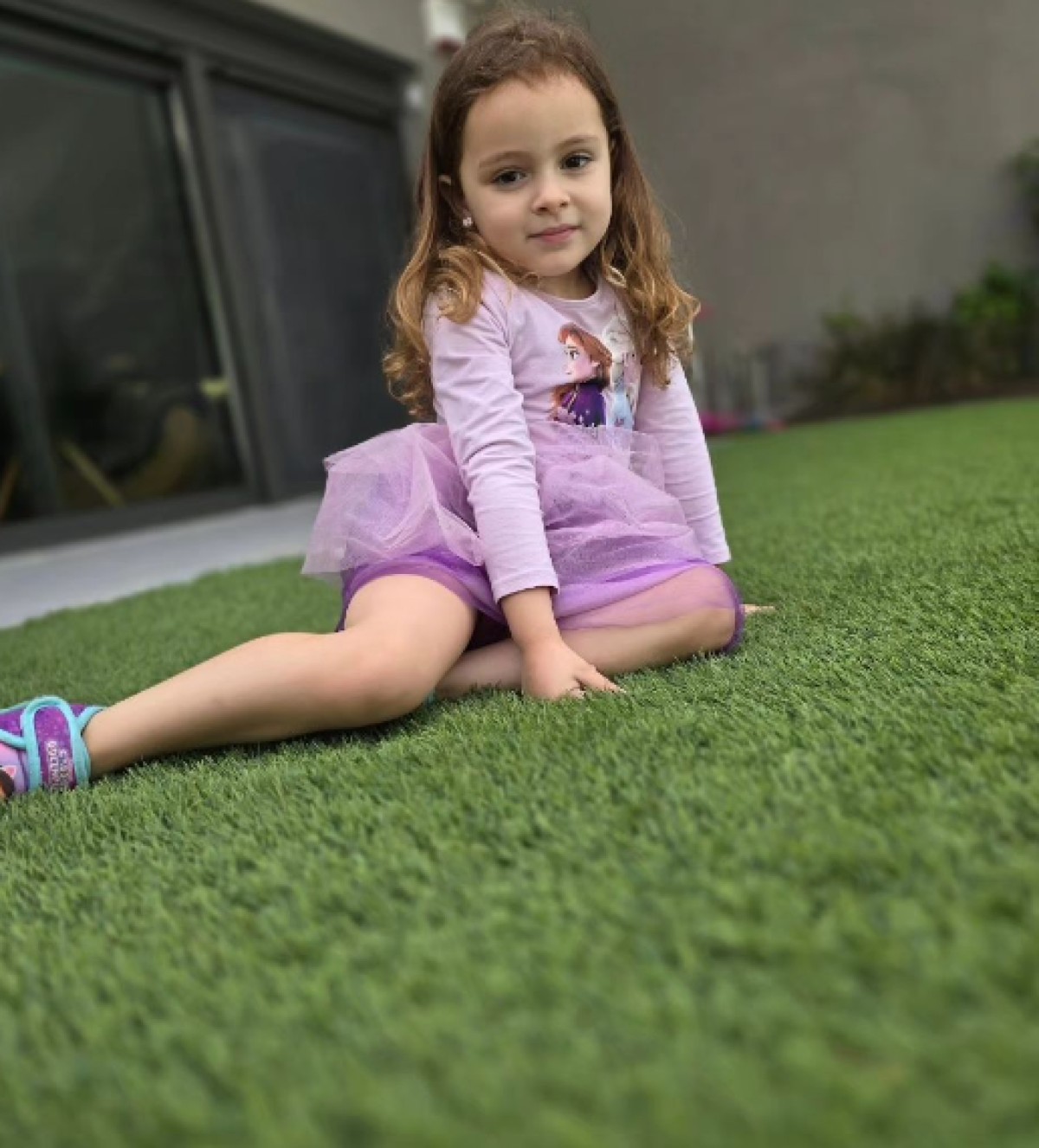 Η Σοφία Πετρούνια στο γρασίδι με λιλά φόρεμα