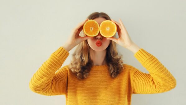 κορίτσι κρατάει πορτοκάλια μπροστά στα μάτια του