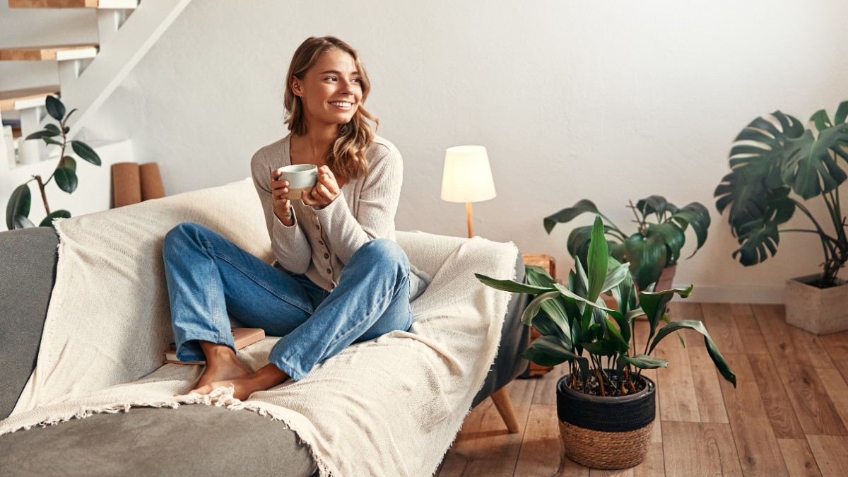 Κοπέλα σε καναπέ με καφέ στο χέρι της