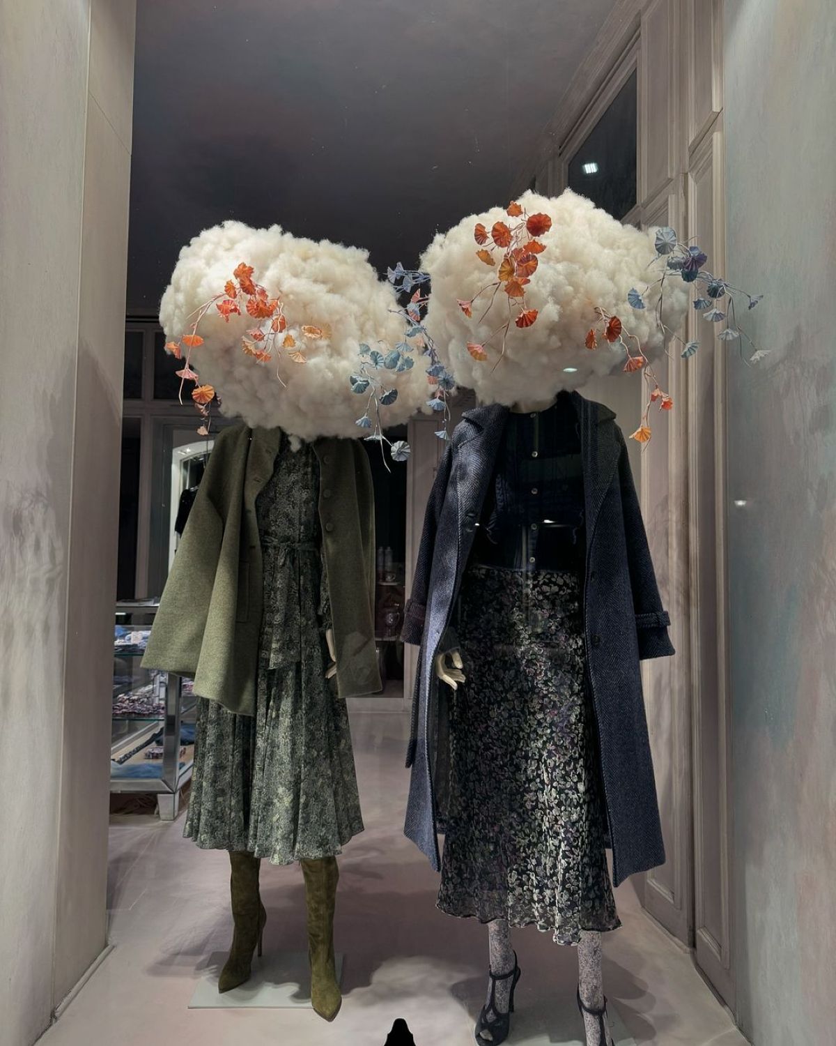 Μαγαζί με δύο κούκλες ντυμένες με φούστα, καπαρντίνα και σύννεφα αντί για κεφάλι