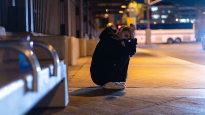 Μια κοπέλα στεναχωρημένη σε στάση λεωφορείου