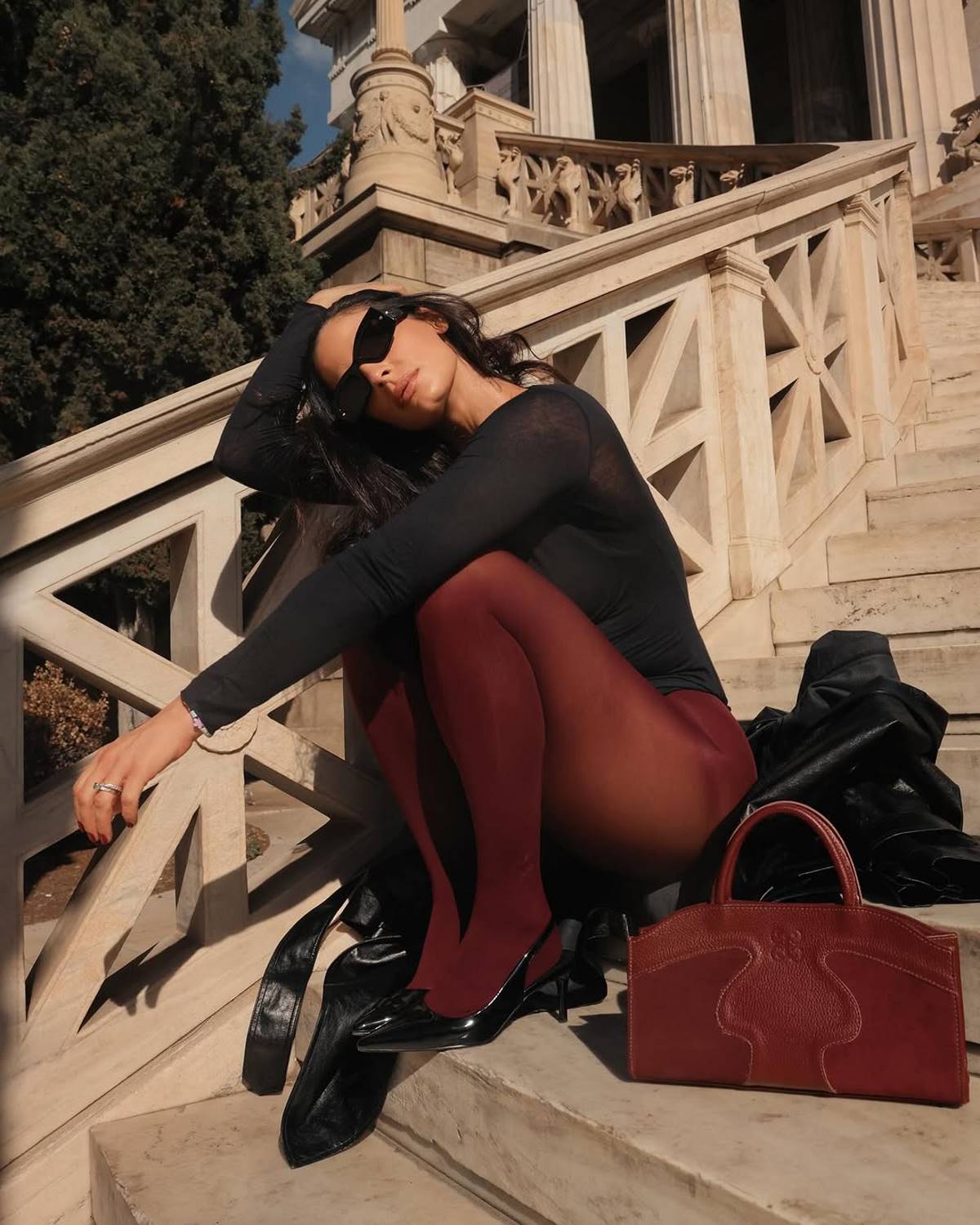 Η Χριστίνα Μπόμπα με καλσόν κάθεται σε σκάλες