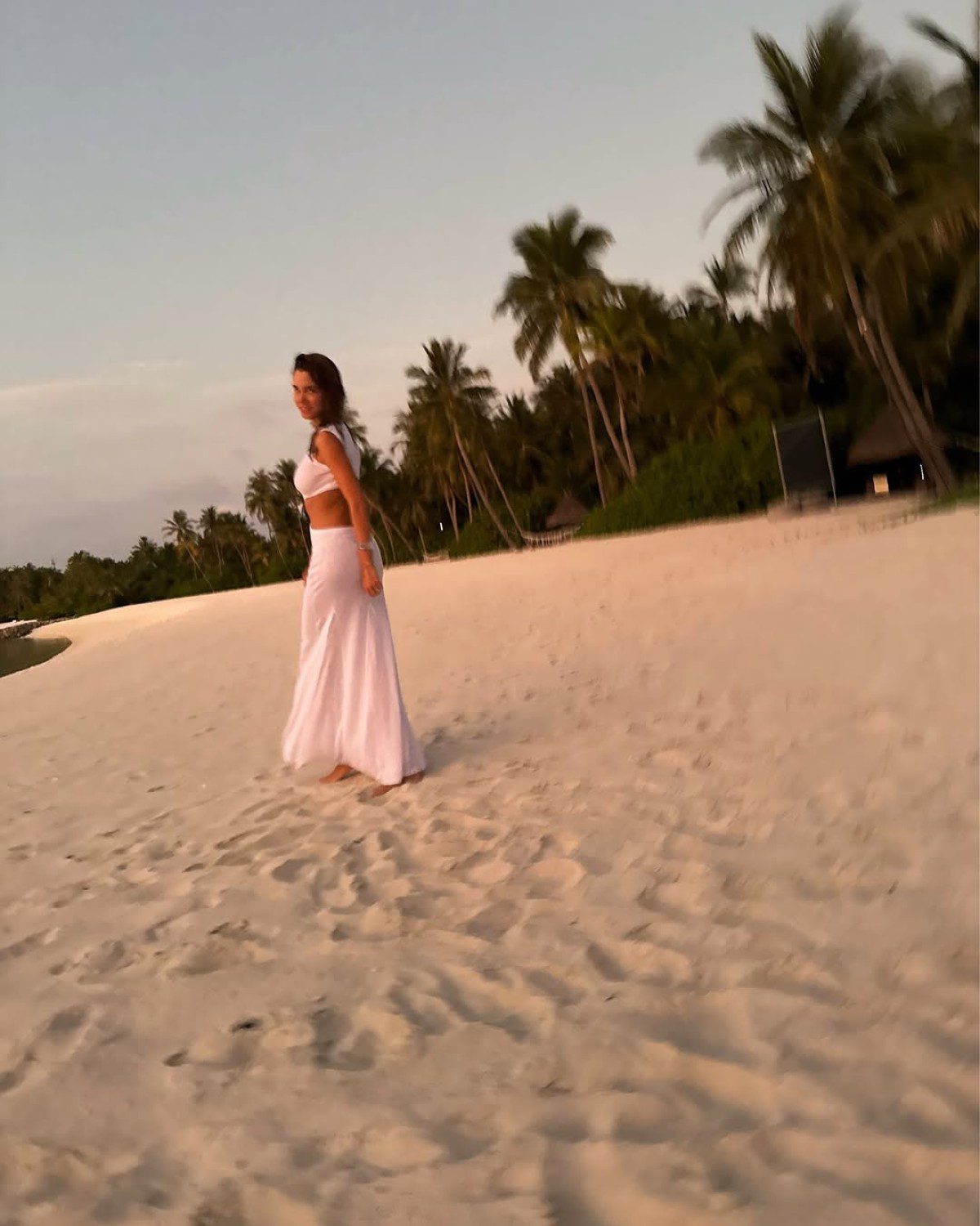 Η Δούκισσα Νομικού σε εξωτική παραλία με λευκό φόρεμα