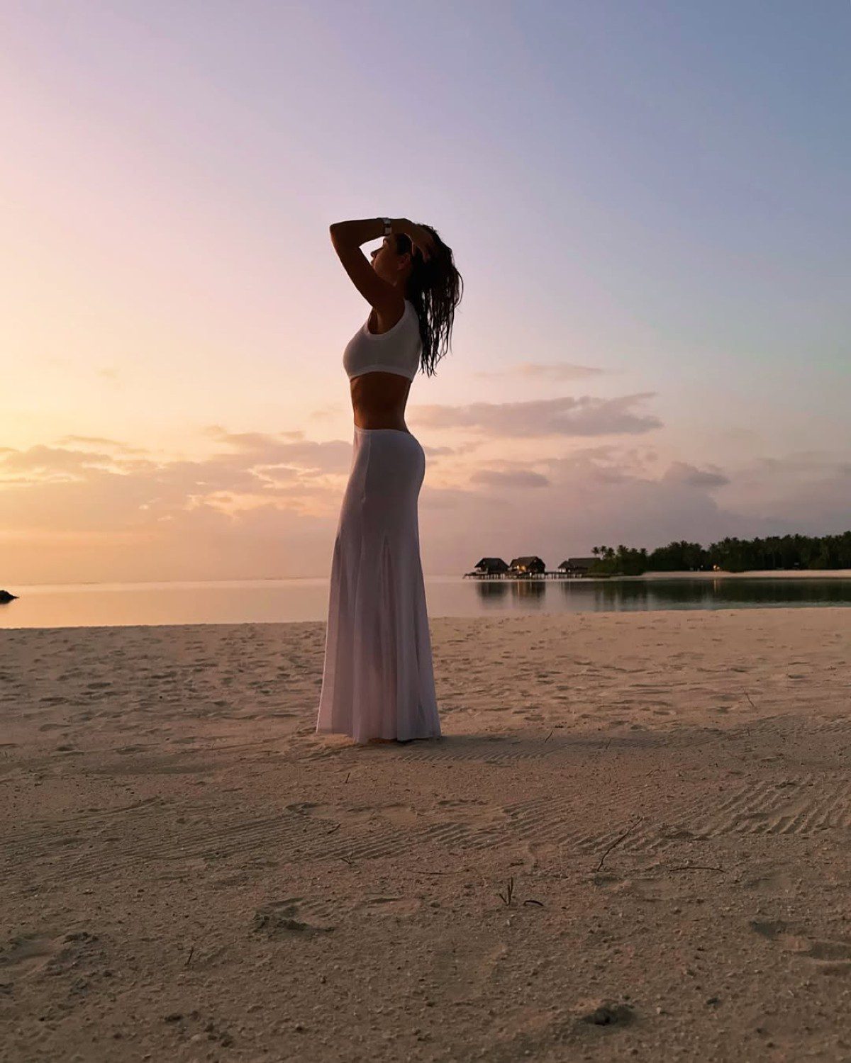 Η Δούκισσα Νομικού σε εξωτική παραλία με λευκό φόρεμα