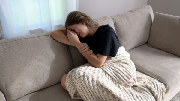 Μια γυναίκα που κλαίει στον καναπέ της