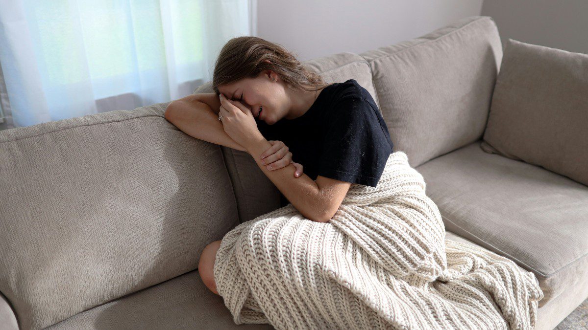 Μια γυναίκα που κλαίει στον καναπέ της