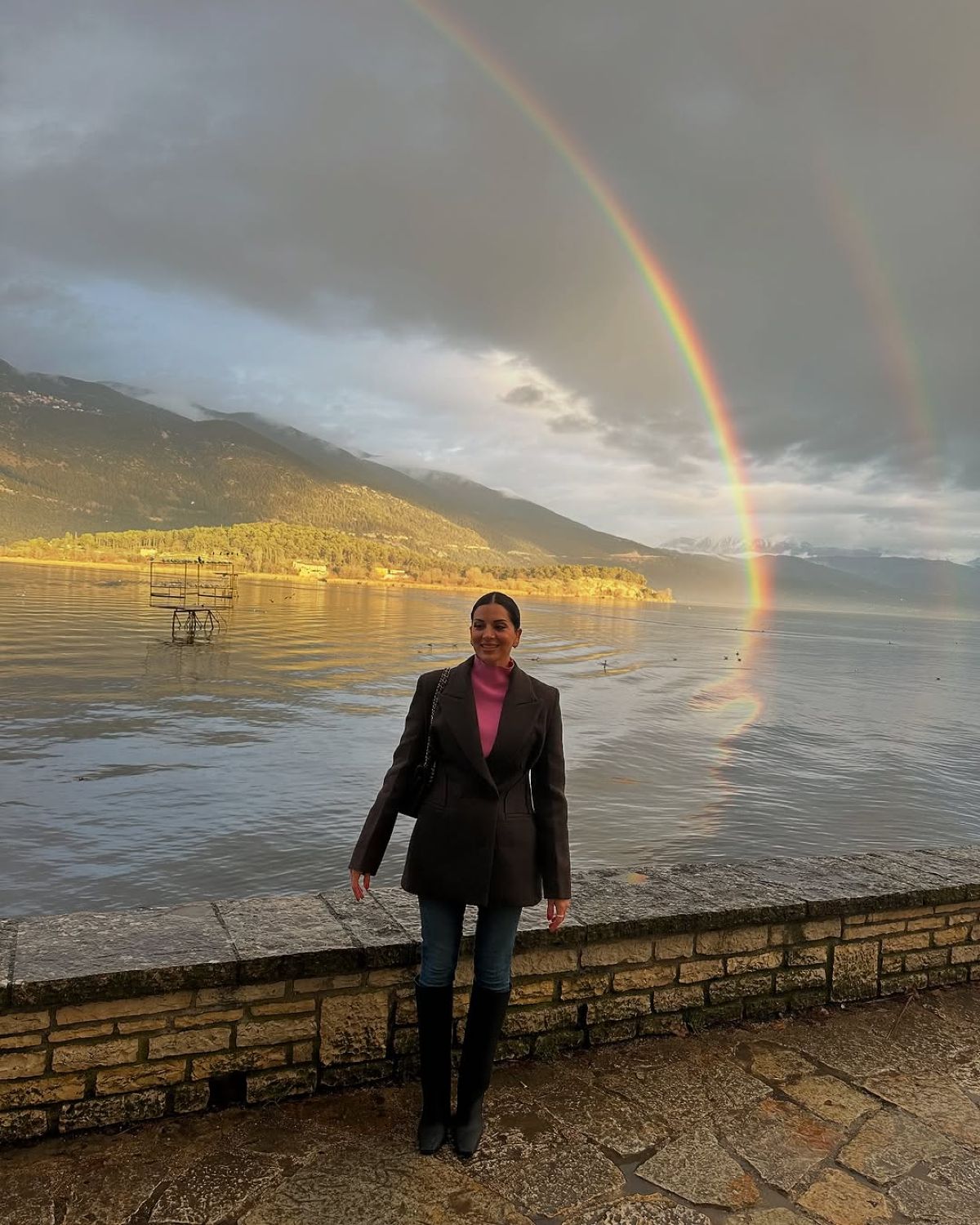 Η Σταματίνα Τσιμτσιλή μπροστά από τη λίμνη Ιωαννίνων και ένα ουράνιο τόξο