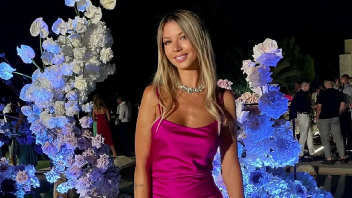 Η Αλεξάνδρα Νικολαίδου ποζάρει μπροστά από λουλούδια σε έξοδό της