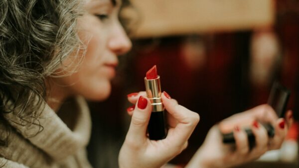 Μια κοπέλα κρατάει ένα κόκκινο κραγιόν