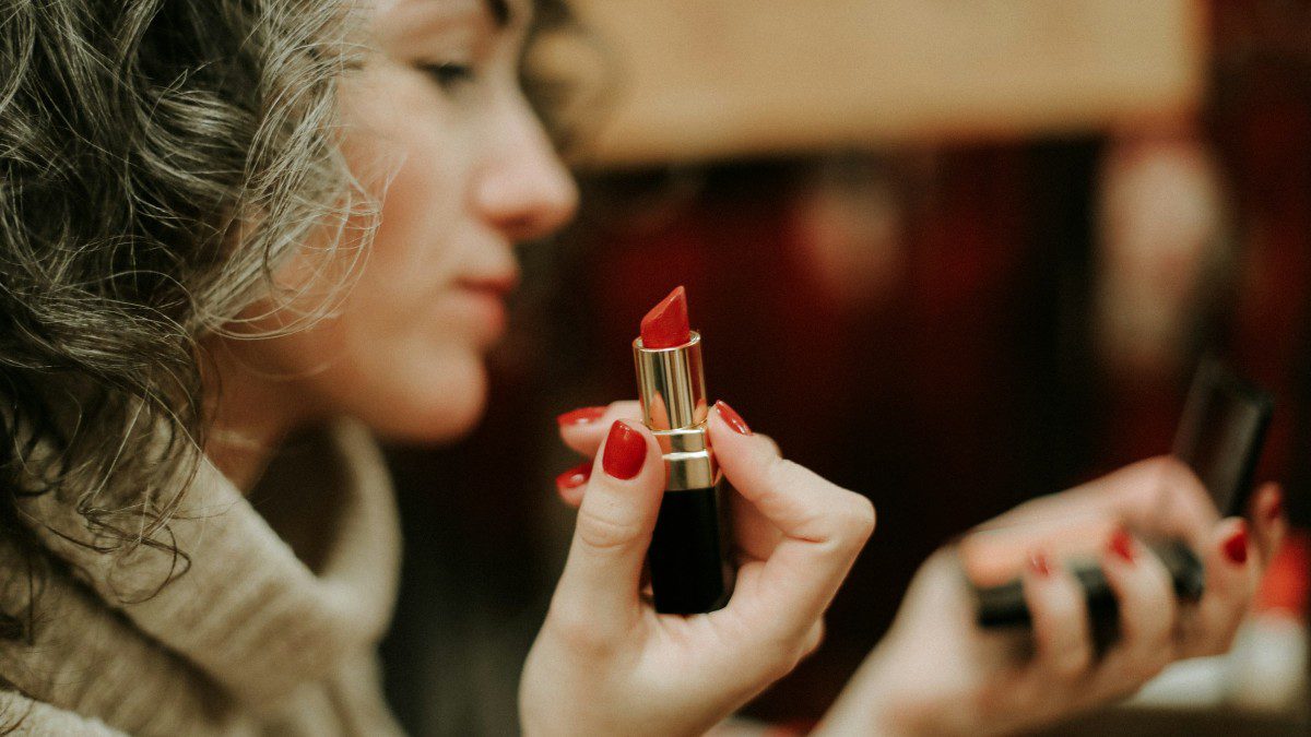 Μια κοπέλα κρατάει ένα κόκκινο κραγιόν