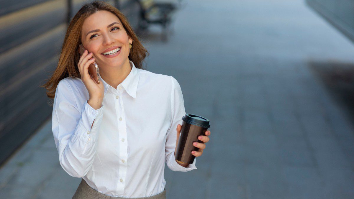 χαρούμενη γυναίκα στον δρόμο μιλάει στο τηλέφωνο