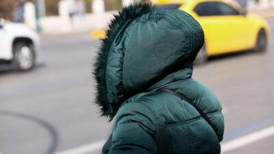 Μια γυναίκα φοράει μπουφάν σε δρόμο της Αθήνας