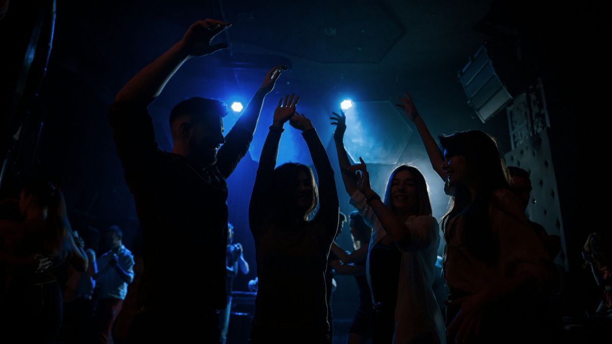 Κόσμος χορεύει σε νυχτερινό μαγαζί.