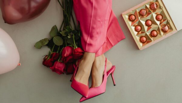 Μια κοπέλα με γόβες, λουλούδια και σοκολατάκια καθισμένη στο πάτωμα