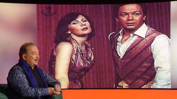 Ο Σταμάτης Φασουλής στο Καλύτερα Αργά και πίσω του φωτογραφία του με την Άννα Παναγιωτοπούλου