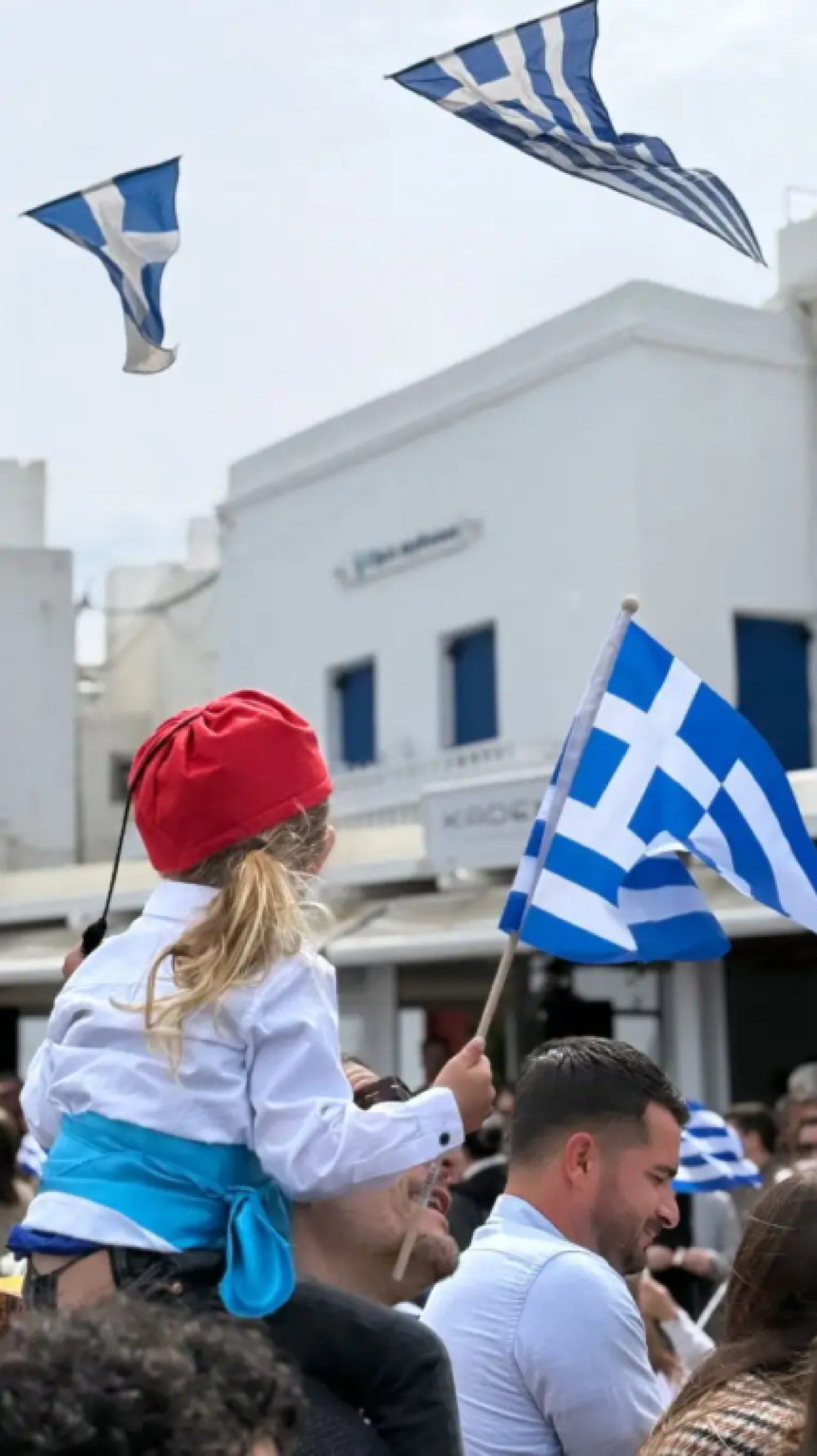 ο γιος της Εριέττας Κούρκουλου στους ώμους του πατέρα του με την ελληνική σημαία