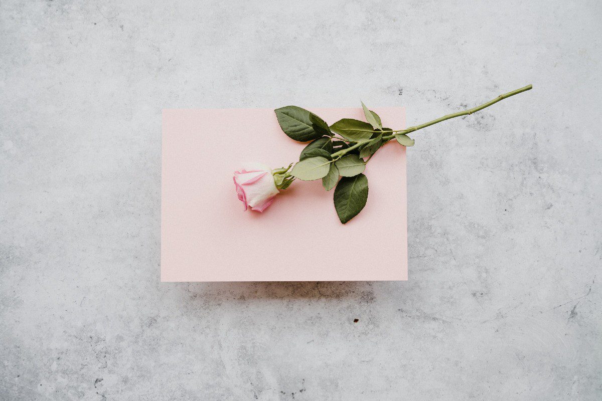 Μια ροζ επιστολή με ένα ροζ τριαντάφυλλο επάνω