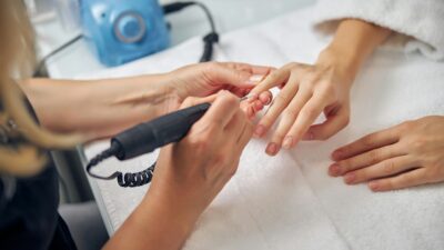 Μια γυναίκα κάνει μανικιούρ στα χέρια άλλης γυναίκας