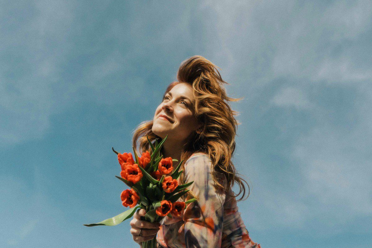 Χαρούμενο κορίτσι κρατάει μπουκέτο με τριαντάφυλλα