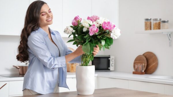 Τα φρέσκα λουλούδια τοποθετεί σε βάζο γυναίκα