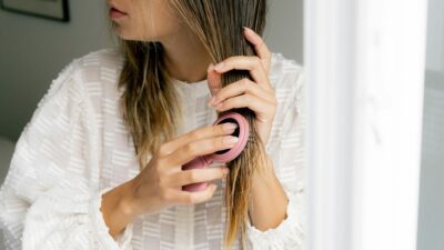 μια κοπέλα φτιάχνει τα μαλλιά της