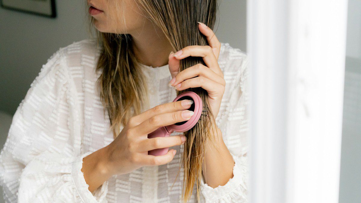 μια κοπέλα φτιάχνει τα μαλλιά της