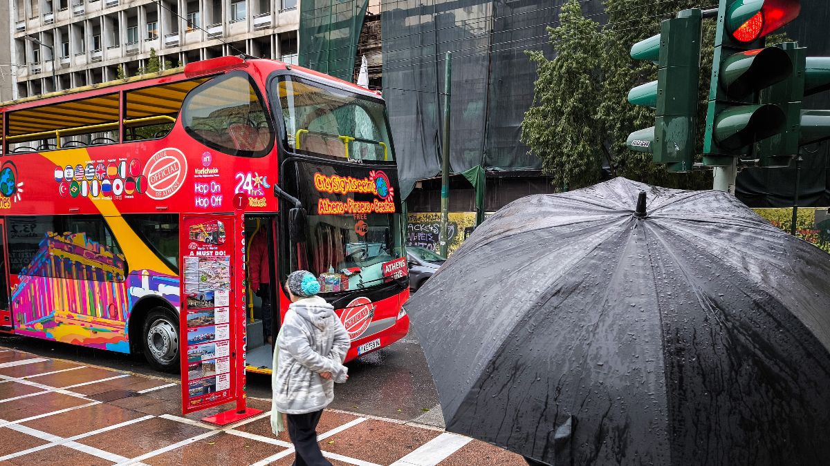 άνθρωποι περπατάνε με σκουφιά και μπουφάν στο κέντρο της Αθήνας