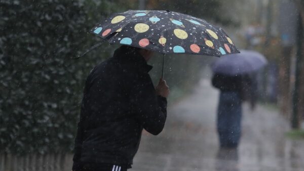 ένας άντρας με ομπρέλα μέσα στη βροχή