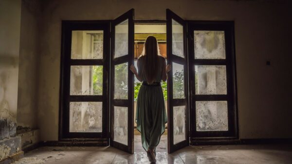 μια κοπέλα ανοίγει μια παλιά πόρτα