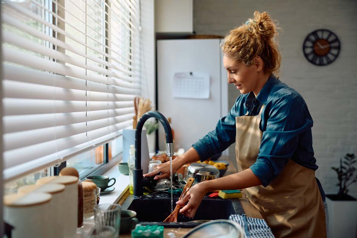 γυναίκα πλένει πιάτα και ταψί
